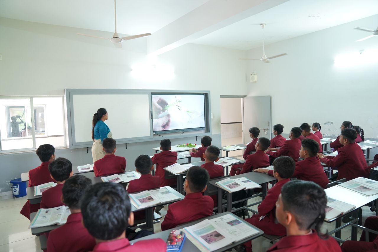 Students attentively learning in a modern classroom with an interactive display at Petlad, Gujarat.